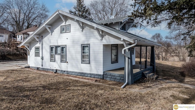 view of side of property featuring a shingled roof