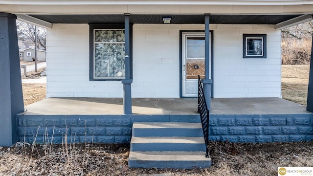 property entrance with a porch and concrete block siding