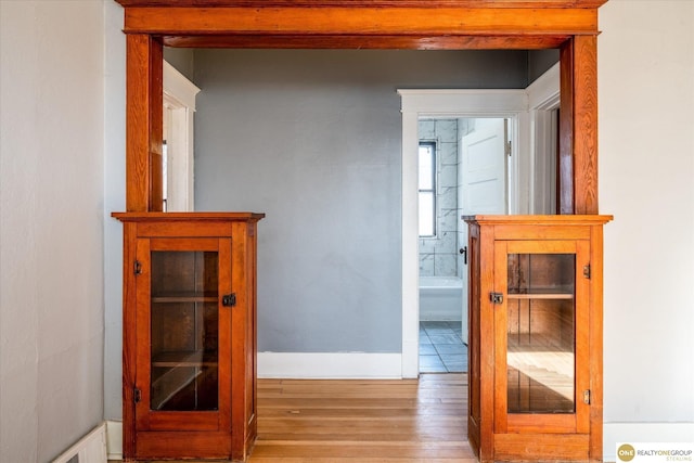 hall with light wood-style flooring and baseboards