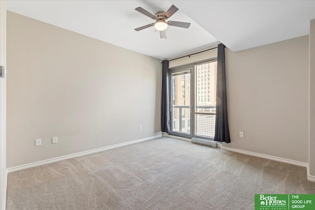 carpeted spare room featuring baseboards and ceiling fan