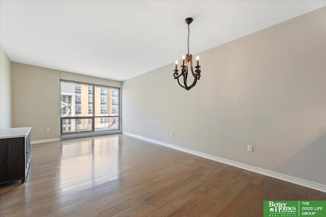 interior space with a chandelier, baseboards, and wood finished floors