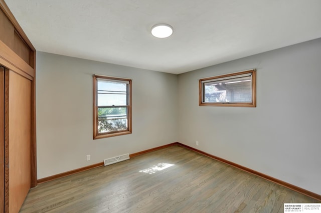 unfurnished bedroom featuring light wood finished floors, visible vents, and baseboards