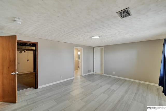 interior space featuring visible vents, baseboards, and a textured ceiling