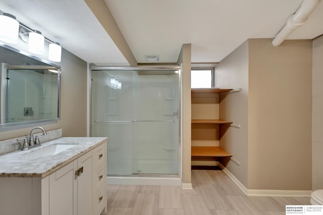 full bath with visible vents, a stall shower, vanity, and baseboards