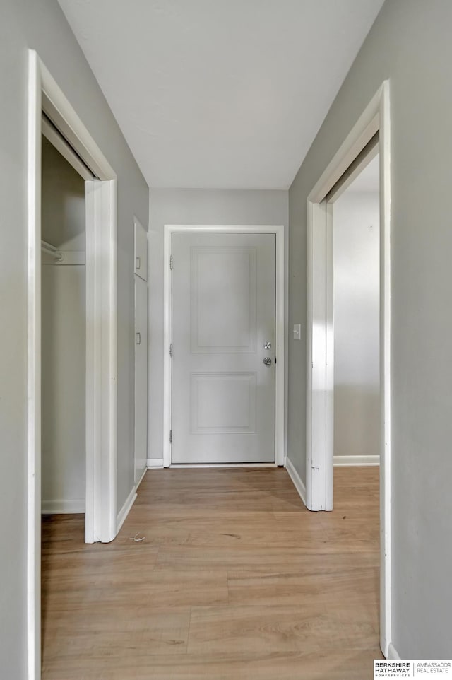 hallway featuring light wood-style floors and baseboards