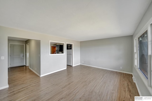 unfurnished room with baseboards and wood finished floors