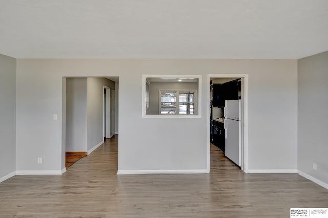 spare room featuring wood finished floors and baseboards