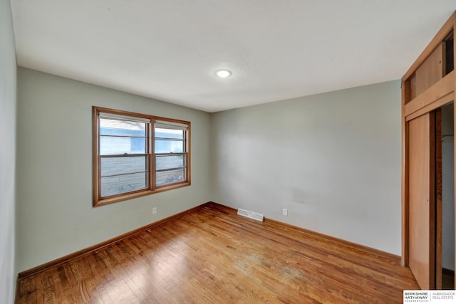 spare room featuring visible vents, baseboards, and light wood-style floors