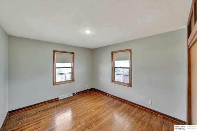 spare room with a wealth of natural light, visible vents, and light wood-type flooring