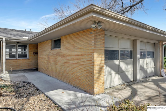 view of property exterior with a garage and brick siding