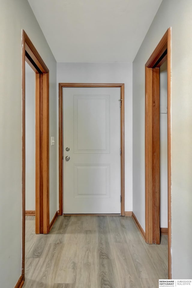 hall with light wood-type flooring and baseboards