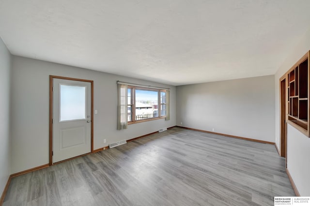 foyer entrance with visible vents, baseboards, and light wood-style floors