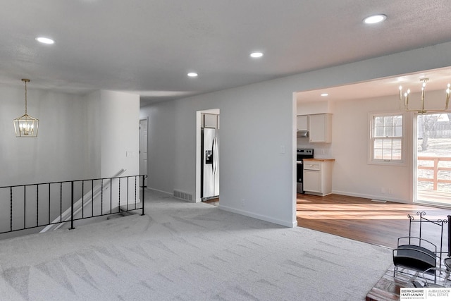 living room featuring recessed lighting, visible vents, baseboards, and an inviting chandelier