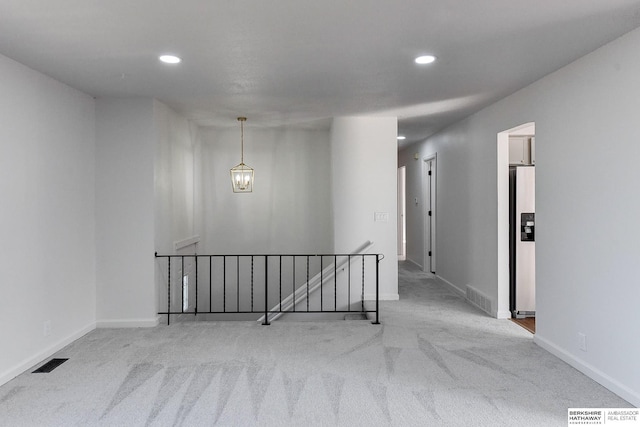 hall with visible vents, an upstairs landing, recessed lighting, carpet flooring, and baseboards