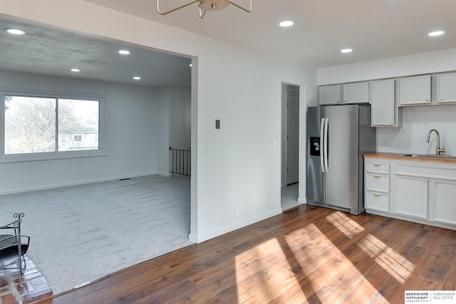 kitchen with wood finished floors, recessed lighting, stainless steel refrigerator with ice dispenser, and a sink