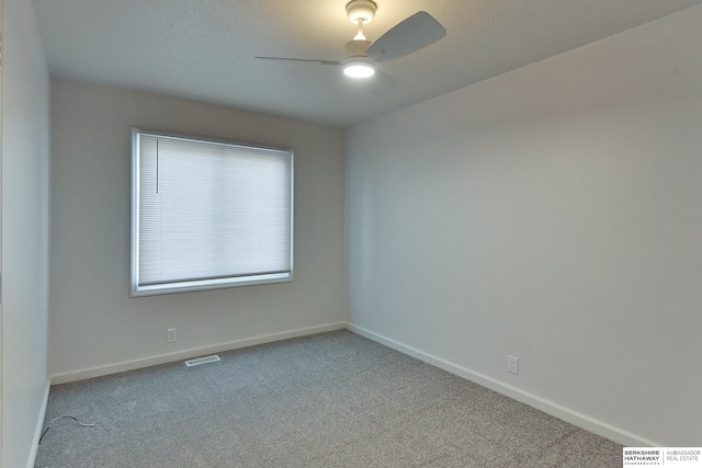 empty room with a ceiling fan, visible vents, carpet, and baseboards