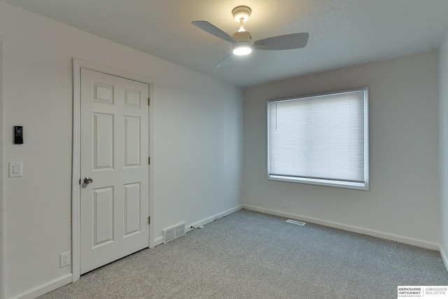 empty room with carpet flooring, baseboards, and visible vents