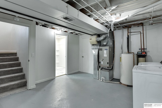 unfinished below grade area with stairway, visible vents, washing machine and dryer, and water heater