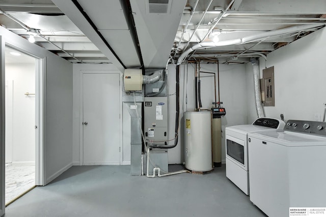 washroom featuring visible vents, electric panel, gas water heater, laundry area, and washing machine and clothes dryer