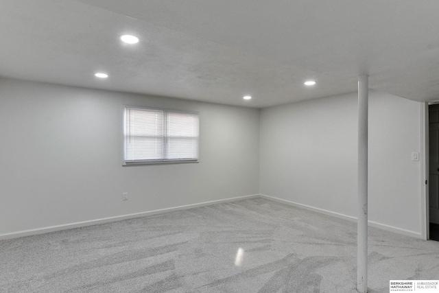 below grade area with recessed lighting, light colored carpet, and baseboards