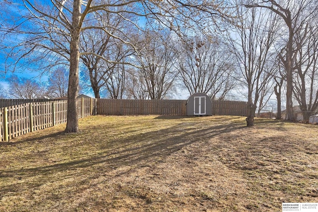 view of yard featuring a storage unit, an outdoor structure, and a fenced backyard