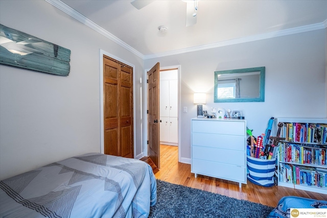 bedroom with crown molding, wood finished floors, and ceiling fan