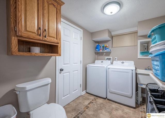 laundry room featuring a sink, a textured ceiling, laundry area, and washing machine and clothes dryer