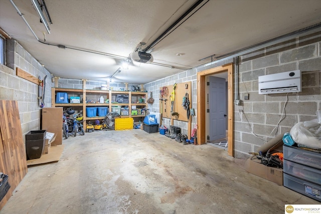 garage with a garage door opener, concrete block wall, and a wall mounted AC