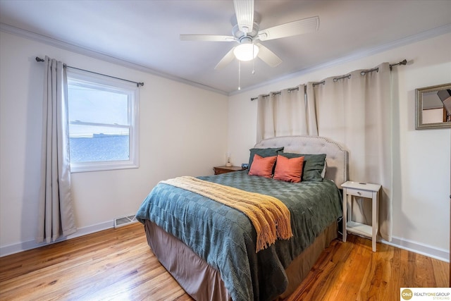 bedroom with crown molding, baseboards, visible vents, and light wood-type flooring