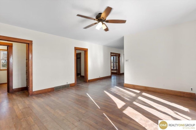 unfurnished room featuring a ceiling fan, baseboards, and wood finished floors
