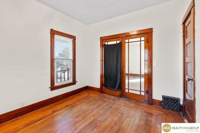 empty room featuring hardwood / wood-style floors and baseboards