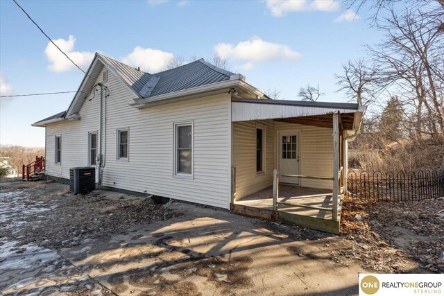 rear view of property featuring cooling unit and fence
