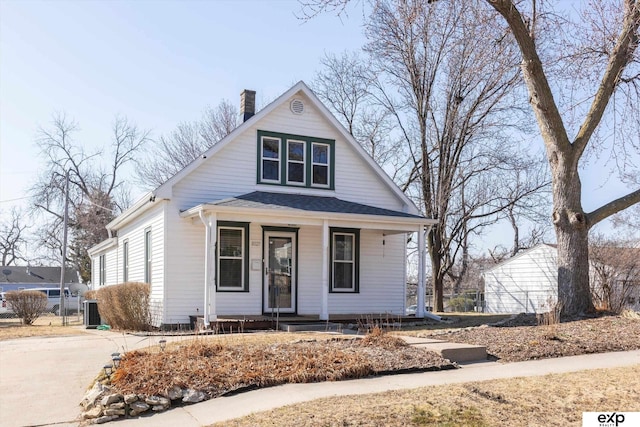 bungalow-style house featuring roof with shingles, a porch, and a chimney