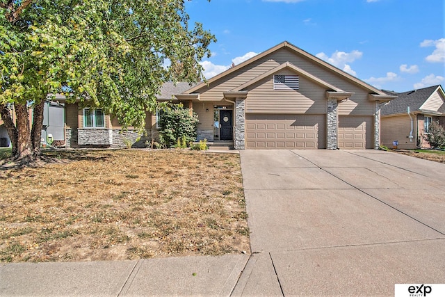 view of front of house featuring stone siding, concrete driveway, and a garage