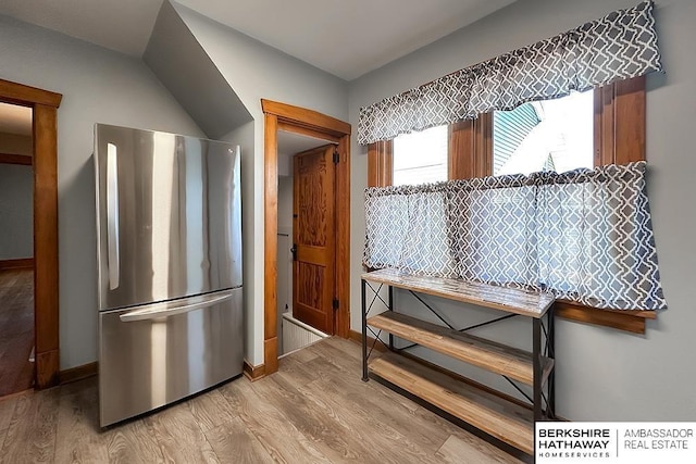 kitchen featuring light wood finished floors, baseboards, and freestanding refrigerator