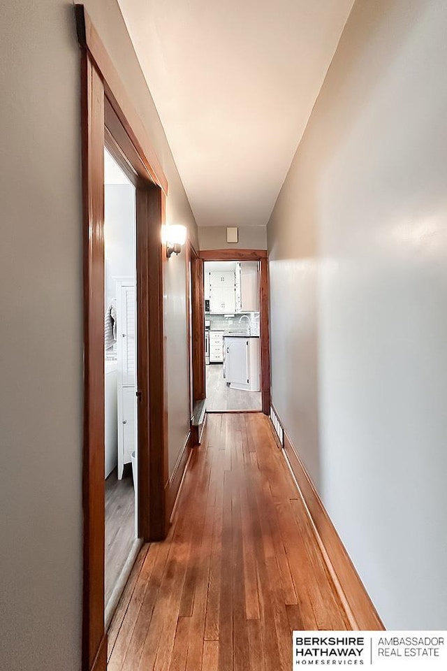 hallway featuring hardwood / wood-style flooring and a sink