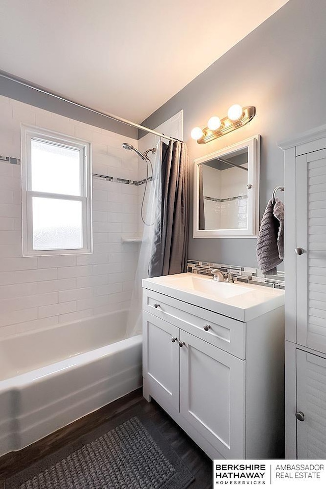 full bath featuring vanity, shower / tub combo with curtain, and wood finished floors