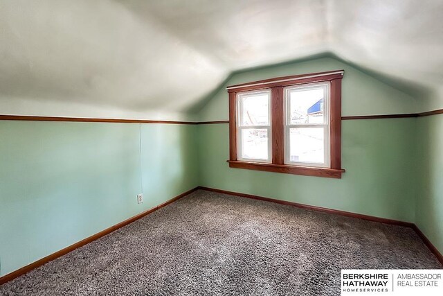 additional living space with carpet flooring, baseboards, and vaulted ceiling