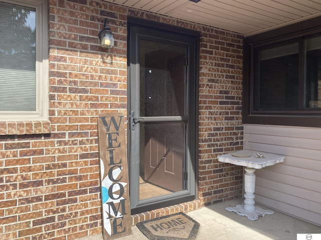 doorway to property featuring brick siding