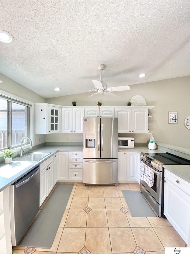 kitchen featuring white cabinetry, stainless steel appliances, ceiling fan, and a sink