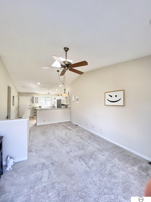 unfurnished living room with baseboards, lofted ceiling, and a ceiling fan