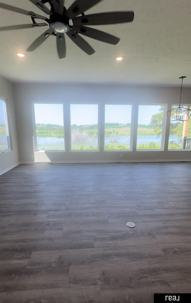 spare room with recessed lighting, baseboards, dark wood-style flooring, and ceiling fan with notable chandelier