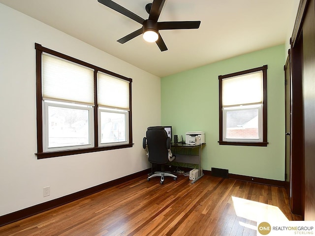 office featuring a ceiling fan, wood finished floors, baseboards, and a wealth of natural light