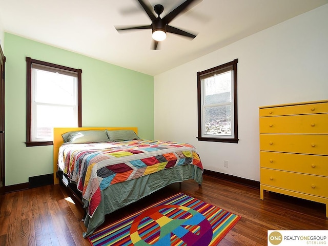 bedroom featuring multiple windows, wood finished floors, and baseboards