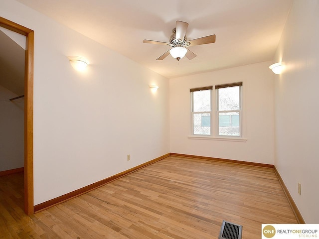 unfurnished room featuring light wood finished floors, visible vents, and baseboards