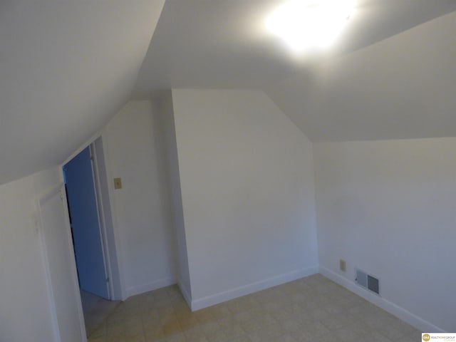 bonus room featuring visible vents, light floors, lofted ceiling, and baseboards