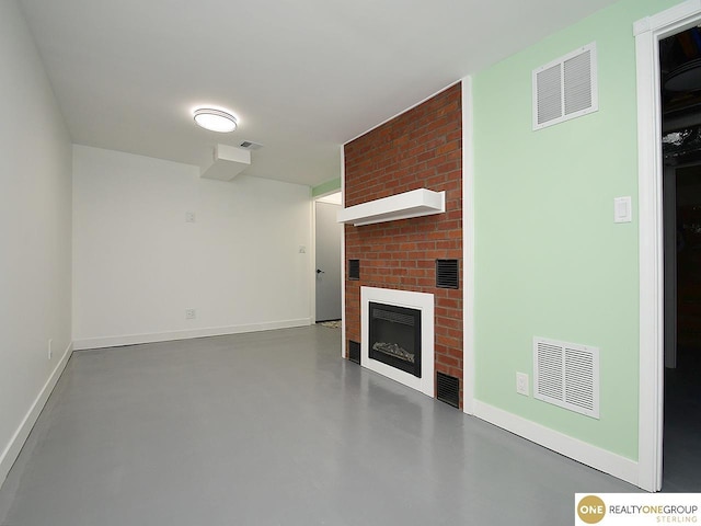 unfurnished living room with visible vents, a fireplace, and concrete flooring