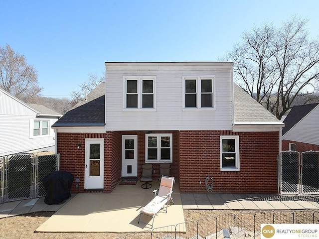 rear view of house featuring a gate, a patio area, and a shingled roof