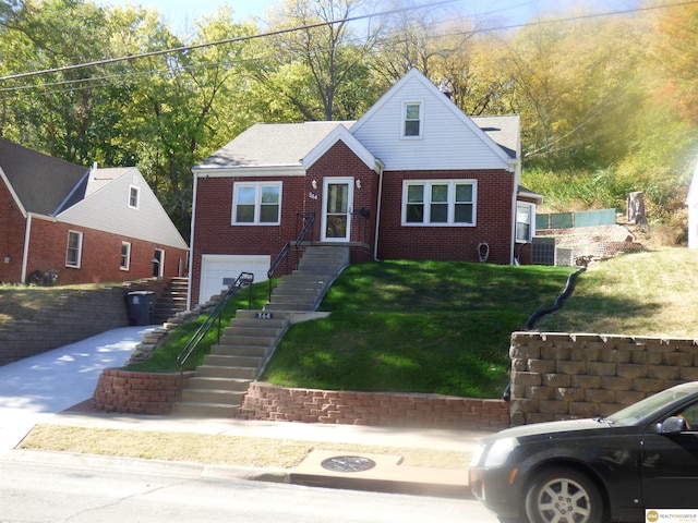 view of front of home featuring brick siding, an attached garage, stairs, and a front yard