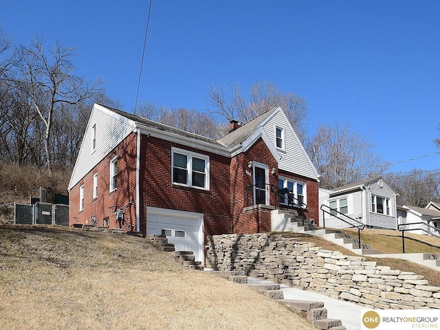 view of front of house with fence, brick siding, and a garage